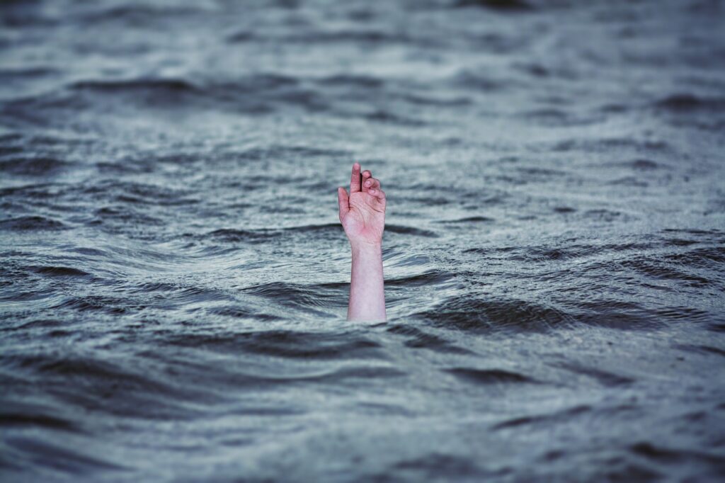 Fotomontage: Hand, die aus dem Meer ragt
